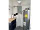 Utility room featuring shelving, pegboard, electrical panel and newer Rheem hot water heater at 602 Park Cir, Bradenton, FL 34207