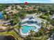 Aerial view of the community pool, clubhouse, palm trees, and surrounding lush landscaping at 6248 Donnington Ct, Sarasota, FL 34238