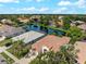 Aerial view of homes with tile roofs surrounding a pond, showcasing the community's layout and landscaping at 6248 Donnington Ct, Sarasota, FL 34238
