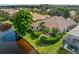 Aerial view of a landscaped home with a tile roof next to a pond, highlighting the property's serene setting at 6248 Donnington Ct, Sarasota, FL 34238