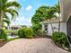Paver patio area surrounded by tropical landscaping and a serene pond view, creating a relaxing outdoor space at 6248 Donnington Ct, Sarasota, FL 34238
