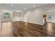 Spacious living room with wood floors, bright natural light, and a view towards the front door and kitchen at 6248 Donnington Ct, Sarasota, FL 34238