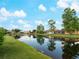 Picturesque pond view showcasing reflections of homes and trees under a sunny sky, enhancing the neighborhood's appeal at 6248 Donnington Ct, Sarasota, FL 34238