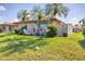 Spacious backyard with lush green lawn, palm trees, and patio area, perfect for outdoor living at 6422 Auburn Ave, Bradenton, FL 34207