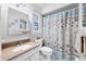 Bright bathroom featuring a patterned shower curtain, clean finishes and white cabinetry at 6422 Auburn Ave, Bradenton, FL 34207