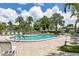 Community pool featuring comfortable lounge chairs surrounded by lush palm trees on a sunny day at 6422 Auburn Ave, Bradenton, FL 34207