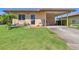 Charming home with a well-manicured lawn, colorful flowers, and a convenient covered carport for easy parking at 6422 Auburn Ave, Bradenton, FL 34207