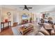 Well-lit living room featuring a ceiling fan, hardwood floors, stylish decor, and access to the kitchen and dining area at 6422 Auburn Ave, Bradenton, FL 34207
