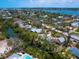 Aerial view of home in a wooded neighborhood with waterfront access at 7320 Melaleuca Way, Siesta Key, FL 34242