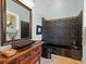 Stylish bathroom features unique tiling, wood vanity, and a modern sink at 7320 Melaleuca Way, Siesta Key, FL 34242