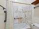Cozy bathroom with white tile shower with bronze fixtures and safety bar at 7320 Melaleuca Way, Siesta Key, FL 34242
