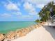 Picturesque beach view with white sand, turquoise water, and shady lounge area at 7320 Melaleuca Way, Siesta Key, FL 34242