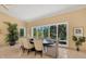 Bright dining room features a large window with backyard views and elegant furnishings at 7320 Melaleuca Way, Siesta Key, FL 34242