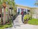 Beautiful home featuring a red door, black railings, lush green lawn, and palm trees at 7320 Melaleuca Way, Siesta Key, FL 34242