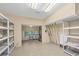 Large, bright multi-purpose room with tile floors, storage shelves, and a folding table at 7320 Melaleuca Way, Siesta Key, FL 34242