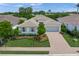 Aerial view of a well-maintained home featuring lush landscaping, a paved driveway, and a pristine exterior at 7717 Sandhill Lake Dr, Sarasota, FL 34241