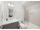 Bright bathroom features a tub with shower, a toilet and vanity with grey cabinets at 7717 Sandhill Lake Dr, Sarasota, FL 34241
