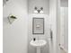 A half bathroom with a pedestal sink, decorative mirror, and modern lighting at 7717 Sandhill Lake Dr, Sarasota, FL 34241