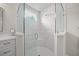 Close up of the modern glass enclosed shower with marble tile and marble accent at 7717 Sandhill Lake Dr, Sarasota, FL 34241