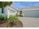The property features a multi-car garage, verdant landscaping, and a driveway paved with pavers at 7717 Sandhill Lake Dr, Sarasota, FL 34241