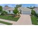 Charming single-story home with a well-manicured lawn and a neatly paved driveway leading to a two-car garage at 7717 Sandhill Lake Dr, Sarasota, FL 34241