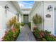 Paver walkway leading to the home's entrance, featuring blooming flowers and decorative plants at 7717 Sandhill Lake Dr, Sarasota, FL 34241