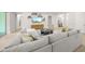 Comfortable living room with light gray sofa and floating shelves above entertainment center at 7717 Sandhill Lake Dr, Sarasota, FL 34241