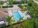 Aerial view of a community pool and jacuzzi, complete with lounge chairs and lush tropical landscaping at 7717 Sandhill Lake Dr, Sarasota, FL 34241