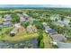 An aerial view shows homes surrounding a lush pond with mature trees in a desirable neighborhood at 7885 Bristol Park Dr, Apollo Beach, FL 33572