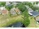 Aerial view displays a landscaped yard backing to a pond, surrounded by lush greenery and nearby houses at 7885 Bristol Park Dr, Apollo Beach, FL 33572