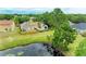 A beautiful pond-side home is surrounded by mature trees and lush lawn in an aerial shot at 7885 Bristol Park Dr, Apollo Beach, FL 33572
