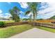 A peaceful backyard oasis featuring a well-manicured lawn, lovely pond view, and concrete patio at 7885 Bristol Park Dr, Apollo Beach, FL 33572