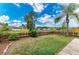 An outdoor oasis with a lush lawn, wooden fence, and beautiful pond view beyond the yard at 7885 Bristol Park Dr, Apollo Beach, FL 33572