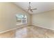 Bedroom featuring a large window, neutral walls, tile flooring and a ceiling fan at 7885 Bristol Park Dr, Apollo Beach, FL 33572