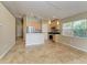 A well-lit kitchen with wooden cabinets, tile floors, stainless steel appliances, and a breakfast bar at 7885 Bristol Park Dr, Apollo Beach, FL 33572