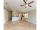 Living room with tile floors, neutral paint, ceiling fan and open kitchen view at 7885 Bristol Park Dr, Apollo Beach, FL 33572