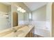 Bright main bathroom with double sinks, shower, large mirror and soaking tub at 7885 Bristol Park Dr, Apollo Beach, FL 33572