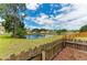 Scenic pond view from backyard with manicured lawn and wood fencing enhance the appeal at 7885 Bristol Park Dr, Apollo Beach, FL 33572