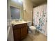Bathroom featuring a vanity with sink, a toilet, and a shower with a floral curtain at 7911 Grand Estuary Trl # 201, Bradenton, FL 34212