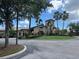 Community clubhouse with landscaped entry and an American flag waving symbolizing community spirit at 7911 Grand Estuary Trl # 201, Bradenton, FL 34212