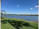 Scenic lake view with a blue sky, fluffy clouds, and lush greenery at 7911 Grand Estuary Trl # 201, Bradenton, FL 34212