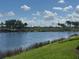 Beautiful lake view with lush green grass in the foreground and a line of trees across the water at 7911 Grand Estuary Trl # 201, Bradenton, FL 34212