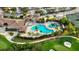 Aerial view of a large community pool with lounging areas surrounded by lush landscaping and golf course at 7911 Grand Estuary Trl # 201, Bradenton, FL 34212