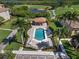 Community pool with sundeck, lounge chairs and palm trees overlooking golf course and pond at 7911 Grand Estuary Trl # 201, Bradenton, FL 34212