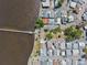 Aerial view of waterfront homes and a long pier along the shoreline with mature trees and well manicured landscaping at 8 Desoto E St, Bradenton, FL 34208