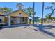 Community office with yellow siding, white trim and golf cart parking with community postings board at 8 Desoto E St, Bradenton, FL 34208