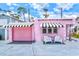 Charming pink exterior with awning-covered windows and a matching garage door at 8 Desoto E St, Bradenton, FL 34208