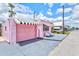 Side view of a pink house with a garage and awning, showcasing its unique charm at 8 Desoto E St, Bradenton, FL 34208