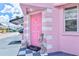 A charming pink front door and exterior with an ornate welcome mat and vintage statue at 8 Desoto E St, Bradenton, FL 34208