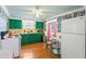 Cozy kitchen showcasing green cabinets, wood floors, and tropical wallpaper for a unique design at 8 Desoto E St, Bradenton, FL 34208